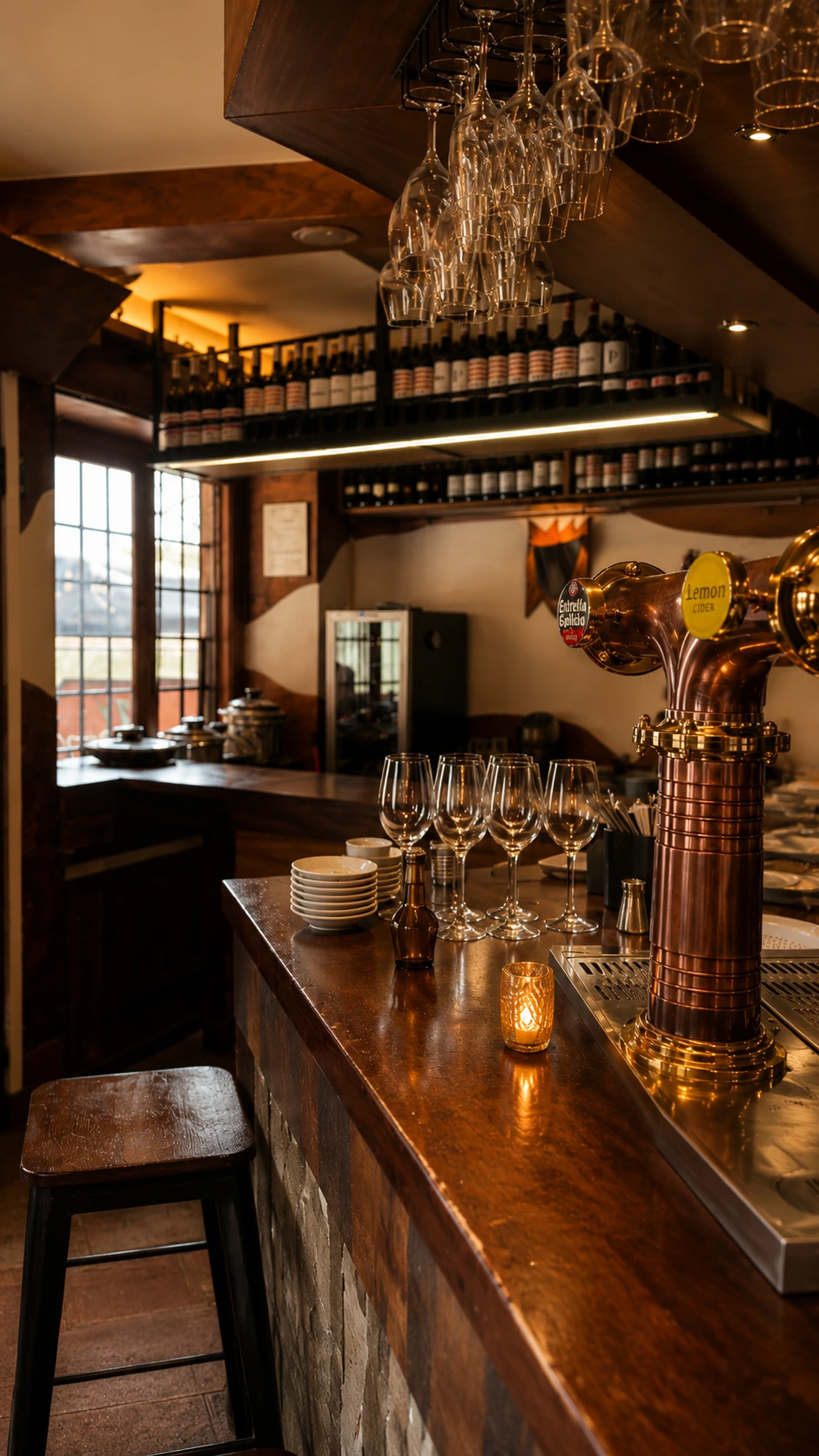 Barra de La Taberna del Chipirón con madera, vidrio y el grifo de cobre.